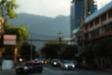 Photo of Blurred view of cityscape with cars on road near beautiful buildings