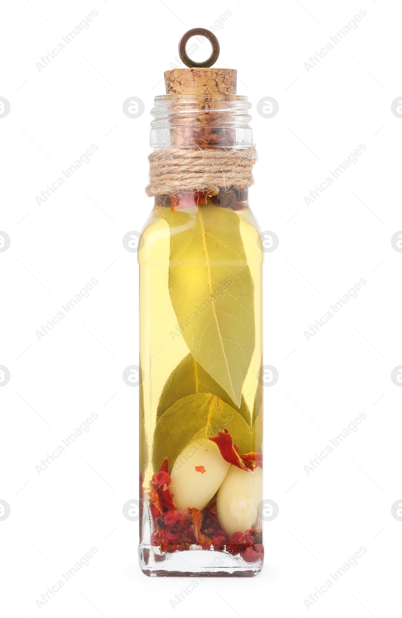 Photo of Glass bottle of cooking oil with spices and herbs isolated on white