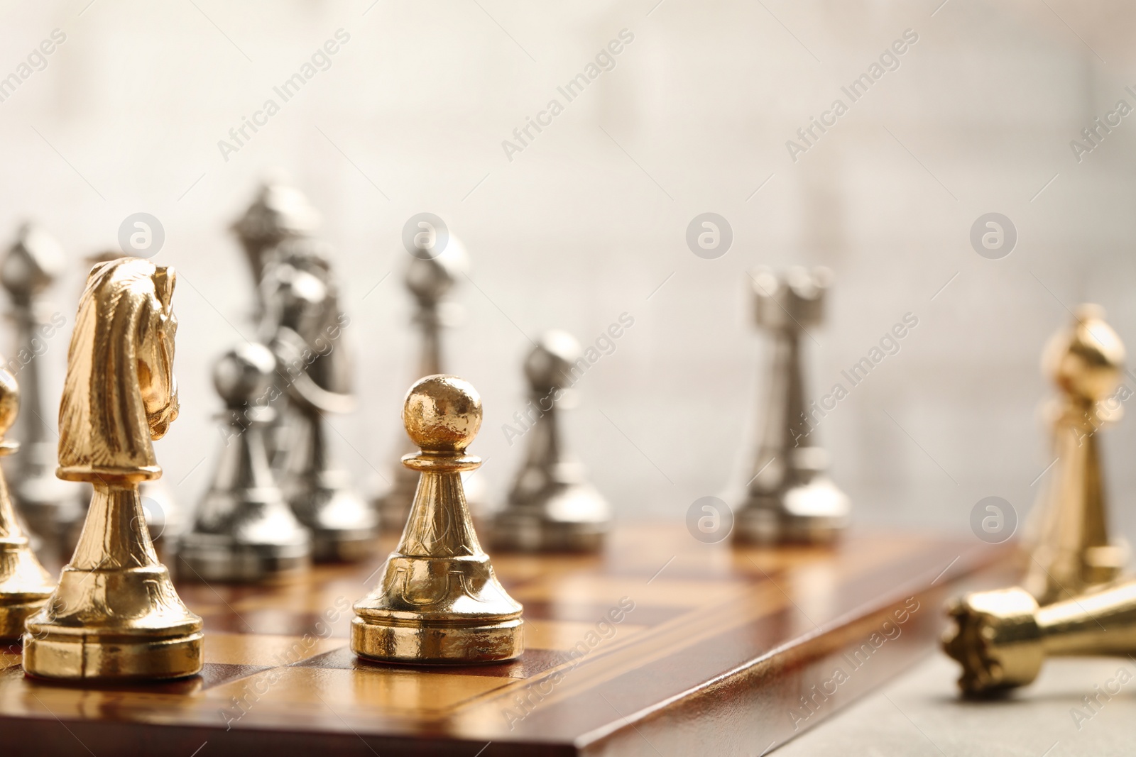 Photo of Chessboard with game pieces on light background, closeup. Space for text