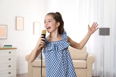 Cute girl singing in microphone at home