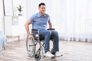 Photo of Happy man sitting in wheelchair at home