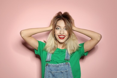 Beautiful young woman with healthy long blonde hair on color background