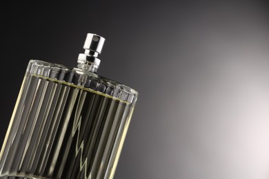 Photo of Luxury men`s perfume in bottle against grey background, space for text