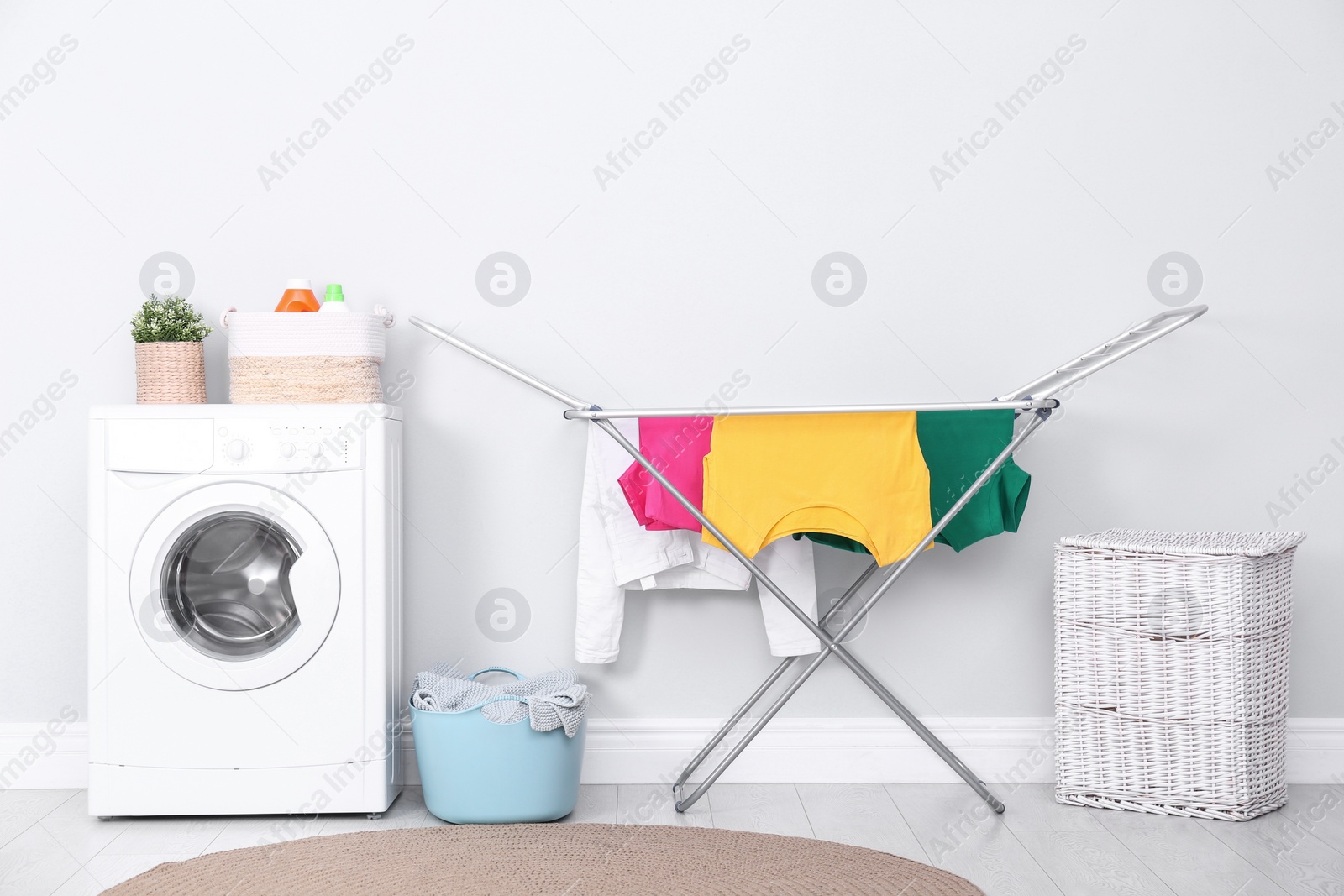 Photo of Clean laundry hanging on drying rack indoors