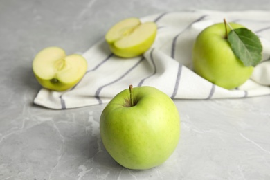 Fresh ripe green apples on grey stone table, space for text