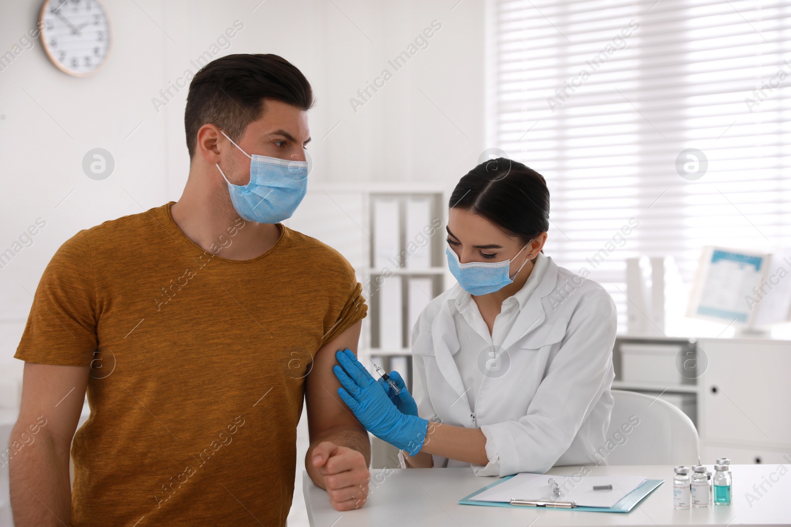 Photo of Doctor giving injection to patient in hospital. Vaccination campaign