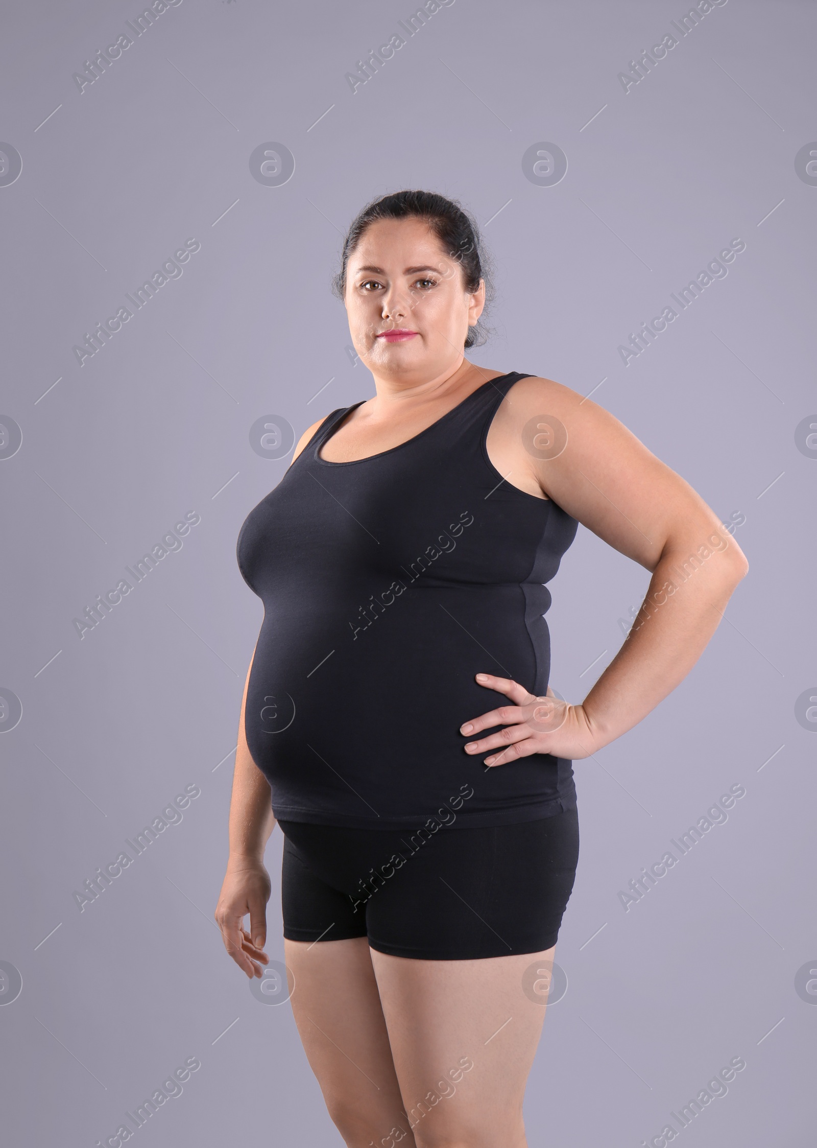 Photo of Fat woman on grey background. Weight loss