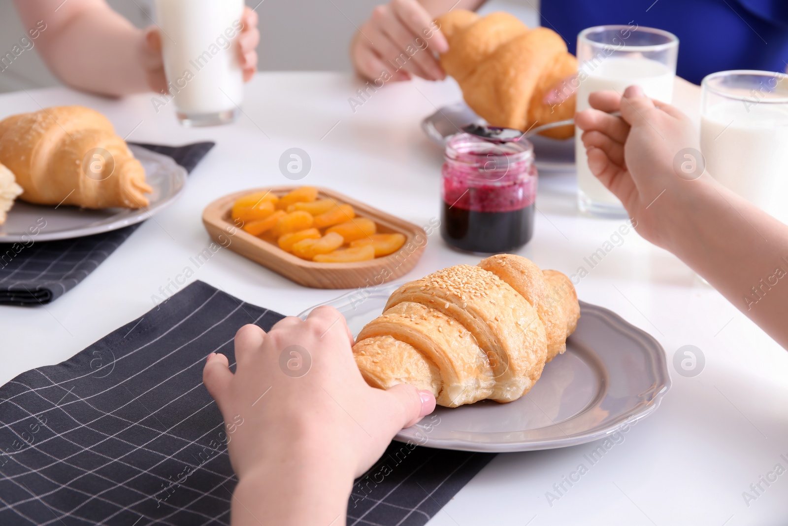 Photo of Women having tasty breakfast with fresh croissants at table