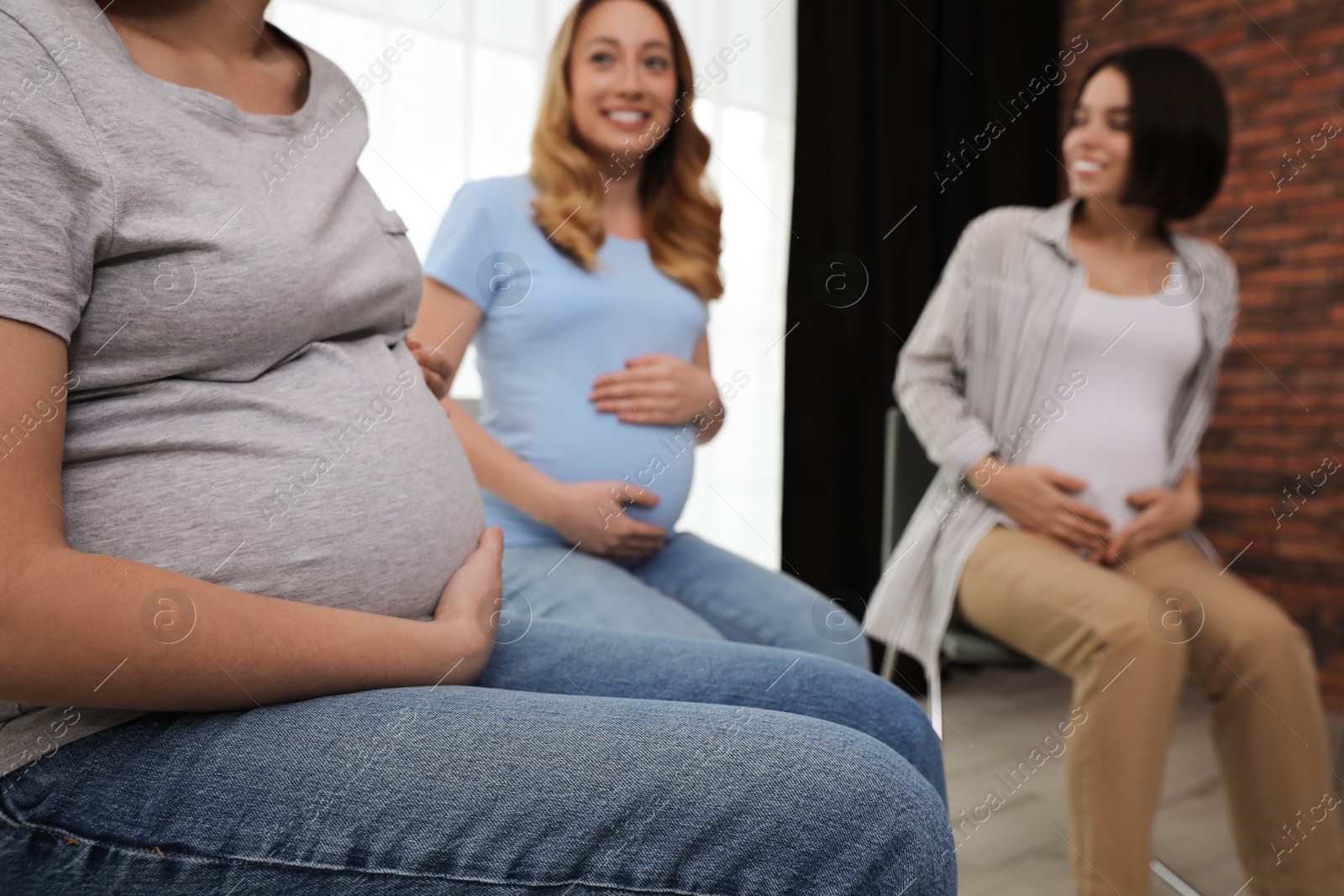 Photo of Group of pregnant women at courses for expectant mothers indoors, closeup