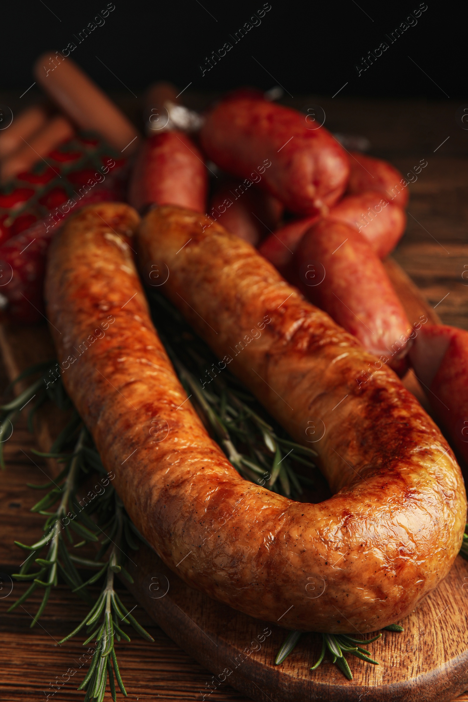 Photo of Different tasty sausages on wooden table, closeup