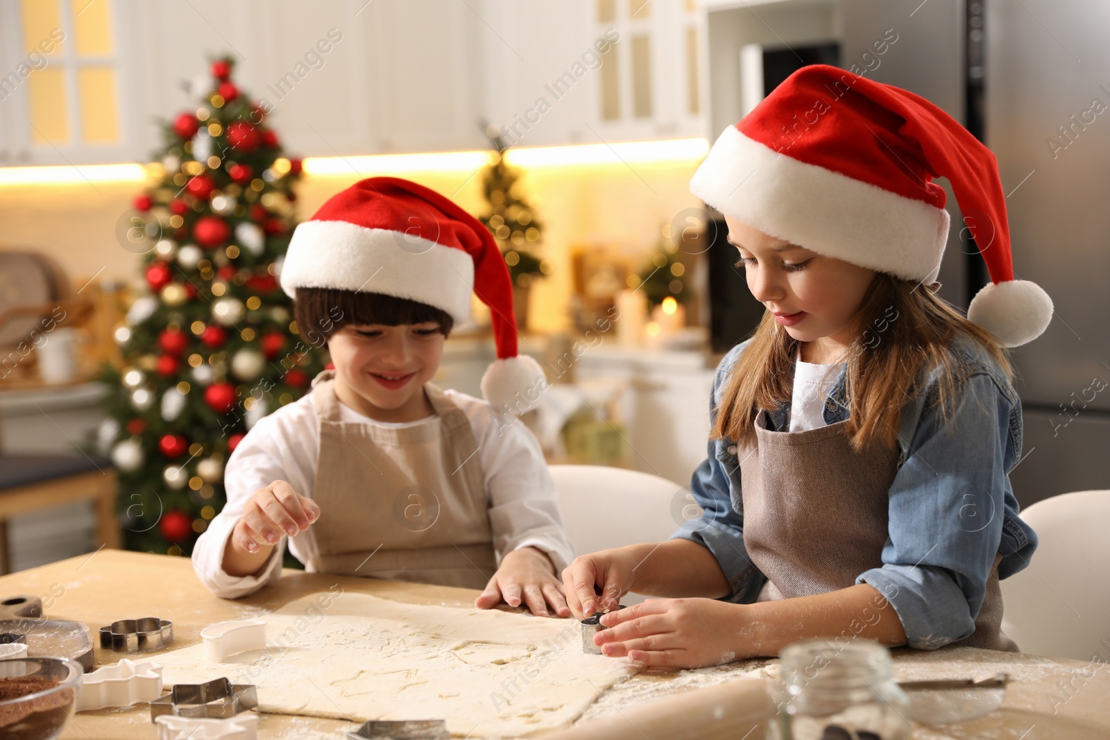 Photo of Cute little children making Christmas cookies in kitchen