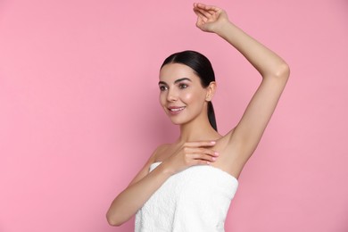 Photo of Young woman showing smooth skin after epilation on pink background, space for text