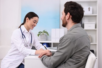 Photo of Doctor consulting patient during appointment in clinic