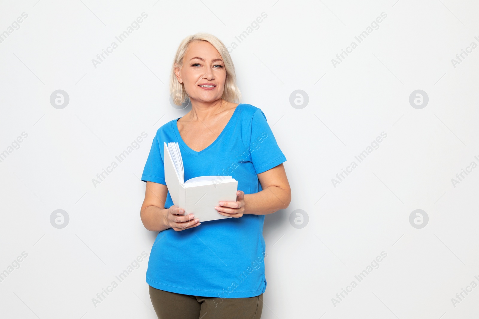 Photo of Senior woman reading book on white background, space for text