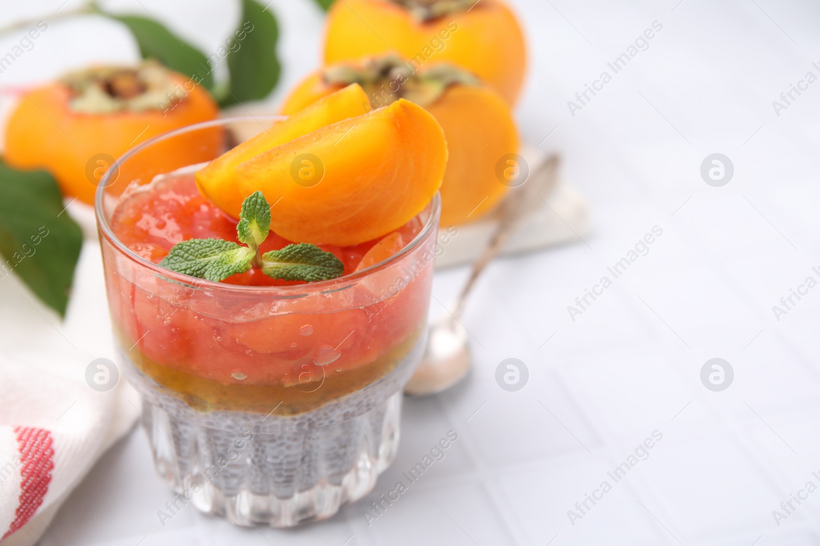 Photo of Delicious dessert with persimmon and chia seeds on table. Space for text