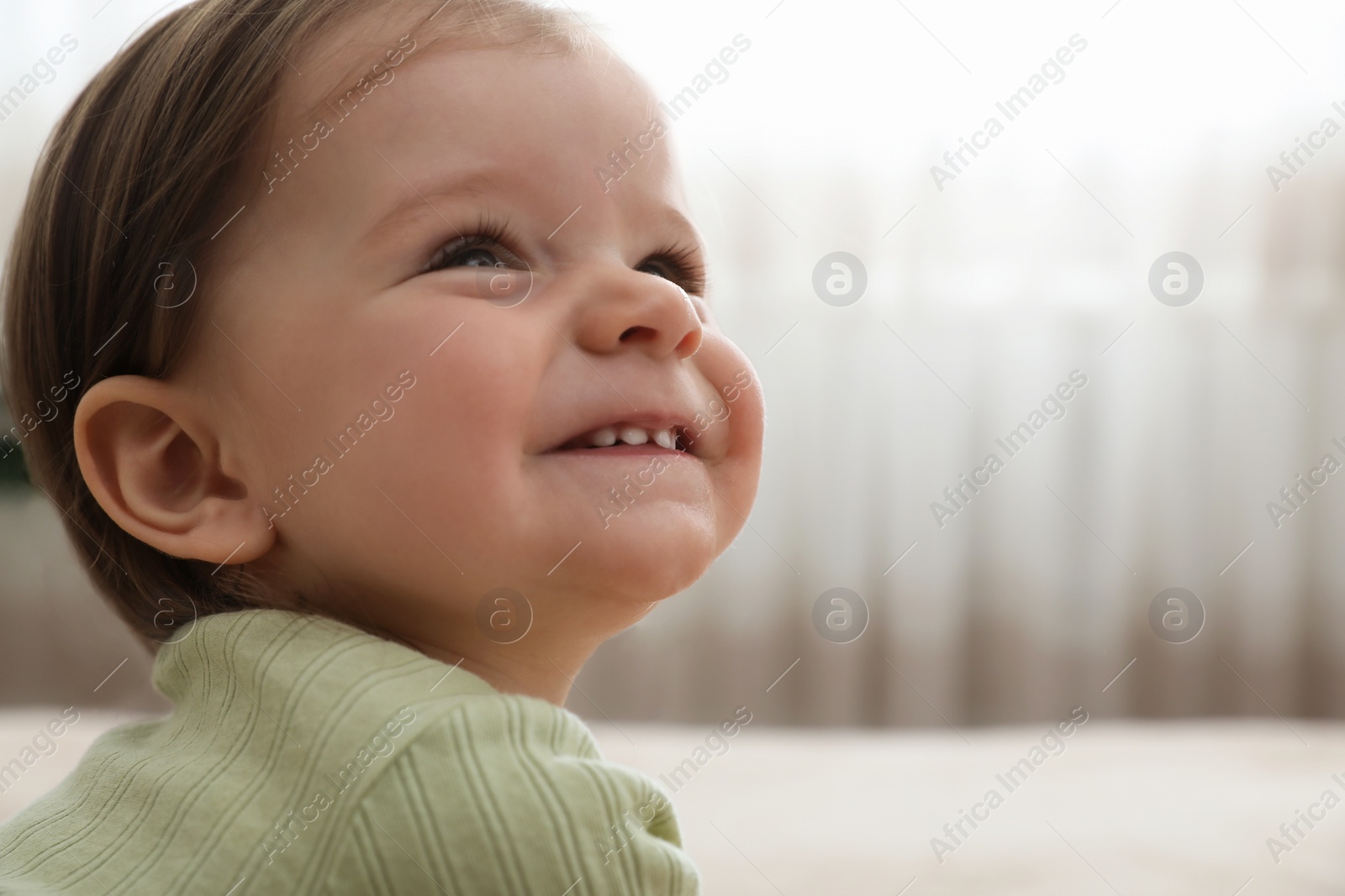 Photo of Cute baby girl at home, space for text