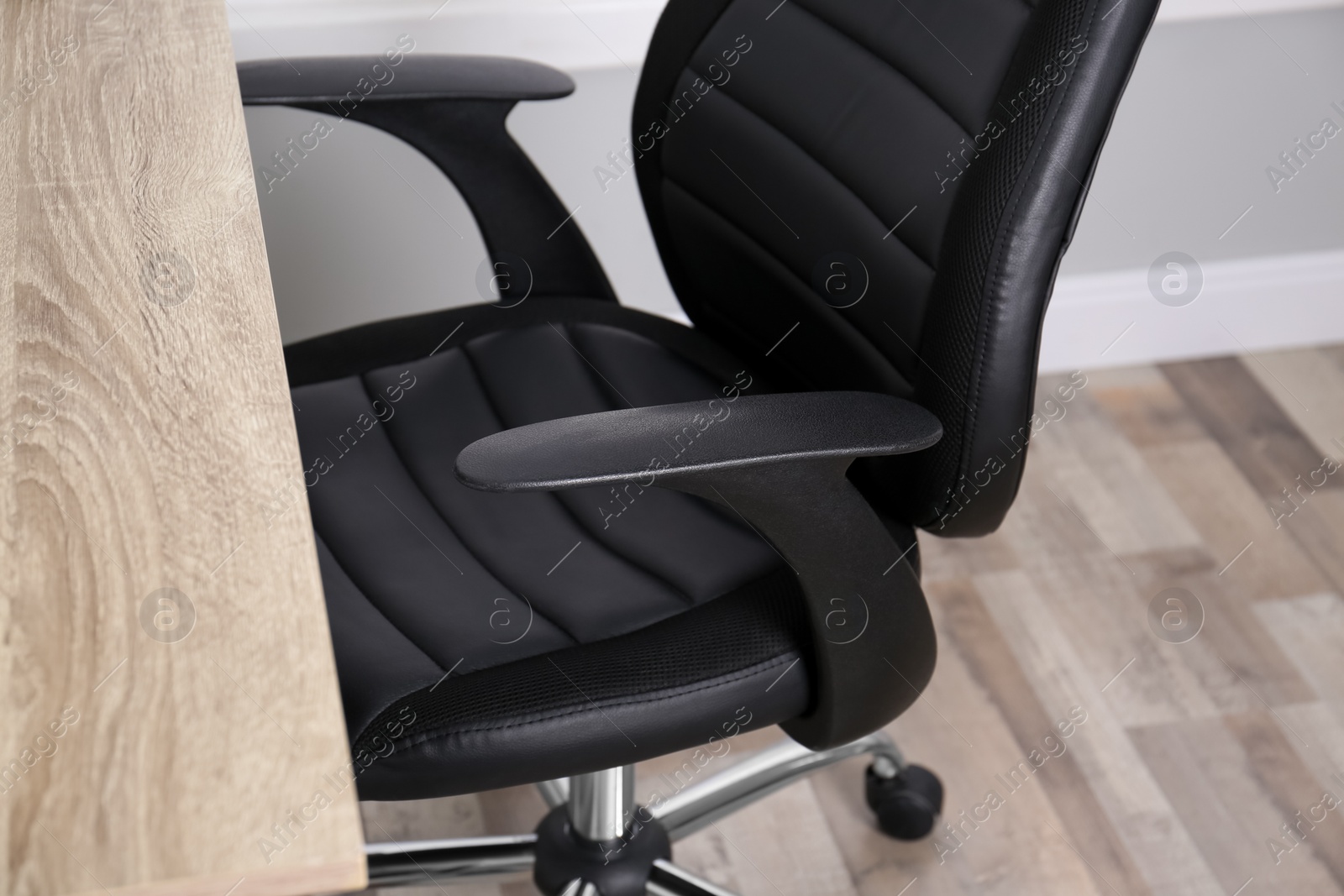 Photo of Comfortable office chair near table in room