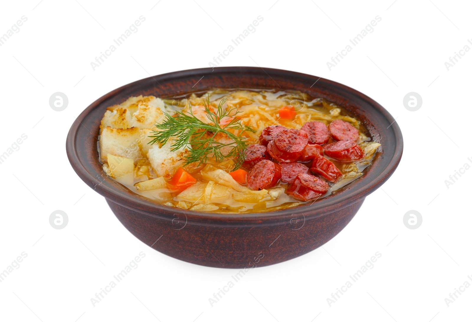 Photo of Bowl of delicious sauerkraut soup with smoked sausages, dill and croutons isolated on white