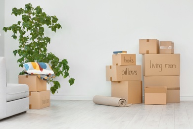 Photo of Cardboard boxes and household stuff indoors. Moving day