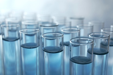 Many test tubes with light blue liquid, closeup