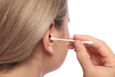 Young woman cleaning ear with cotton swab on white background, closeup