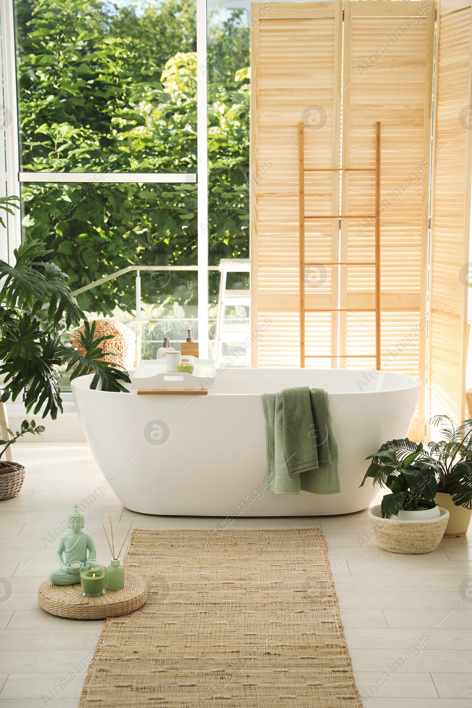 Photo of Stylish bathroom interior with modern tub and beautiful houseplants