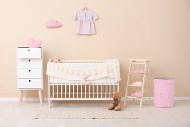 Photo of Stylish baby room interior with comfortable crib