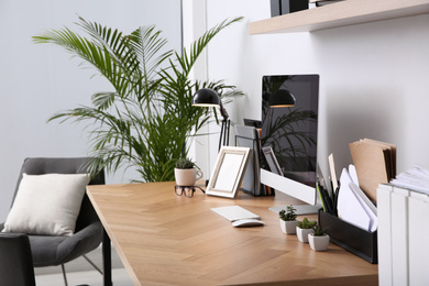 Photo of Modern computer on table in office interior. Stylish workplace