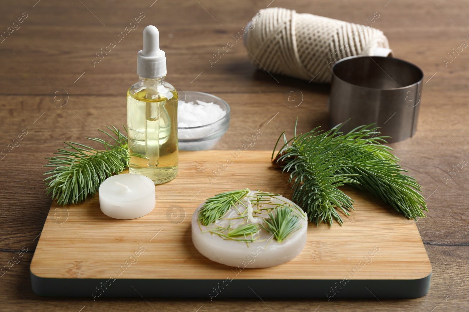 Photo of Board with handmade candle and ingredients on table