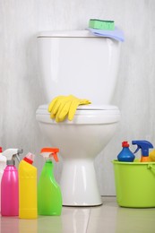 Different cleaning supplies and toilet bowl in bathroom