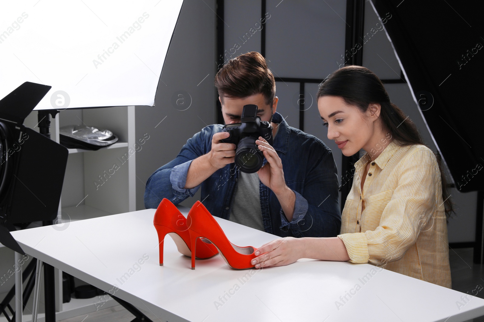 Photo of Professional photographers shooting stylish shoes in studio