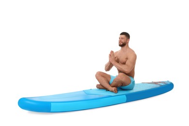 Handsome man practicing yoga on blue SUP board against white background