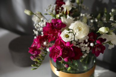 Photo of Beautiful bouquet with spring freesia flowers on white table, closeup