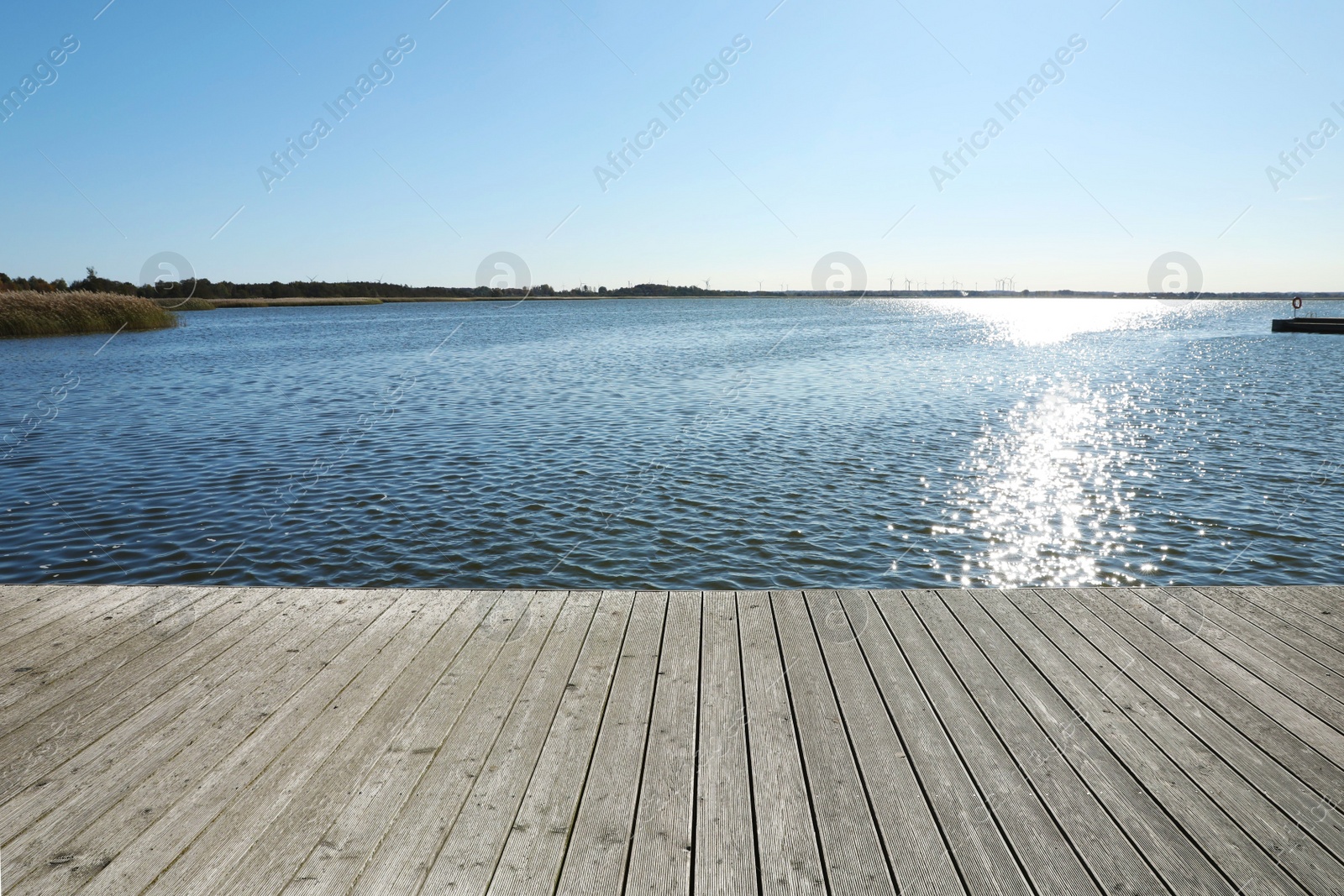 Photo of Beautiful view of wooden terrace near river on sunny day