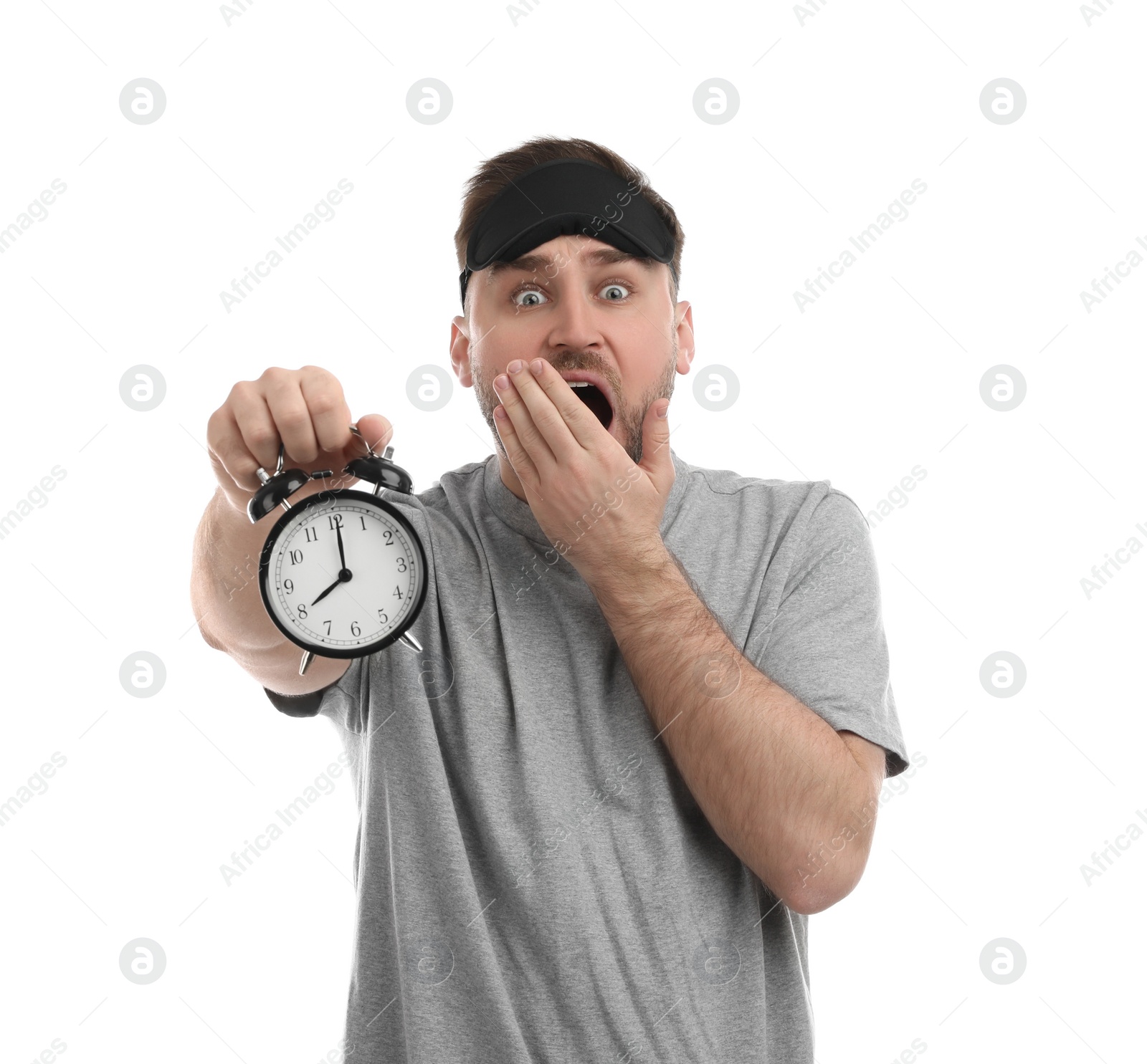 Photo of Emotional overslept man with alarm clock on white background. Being late concept