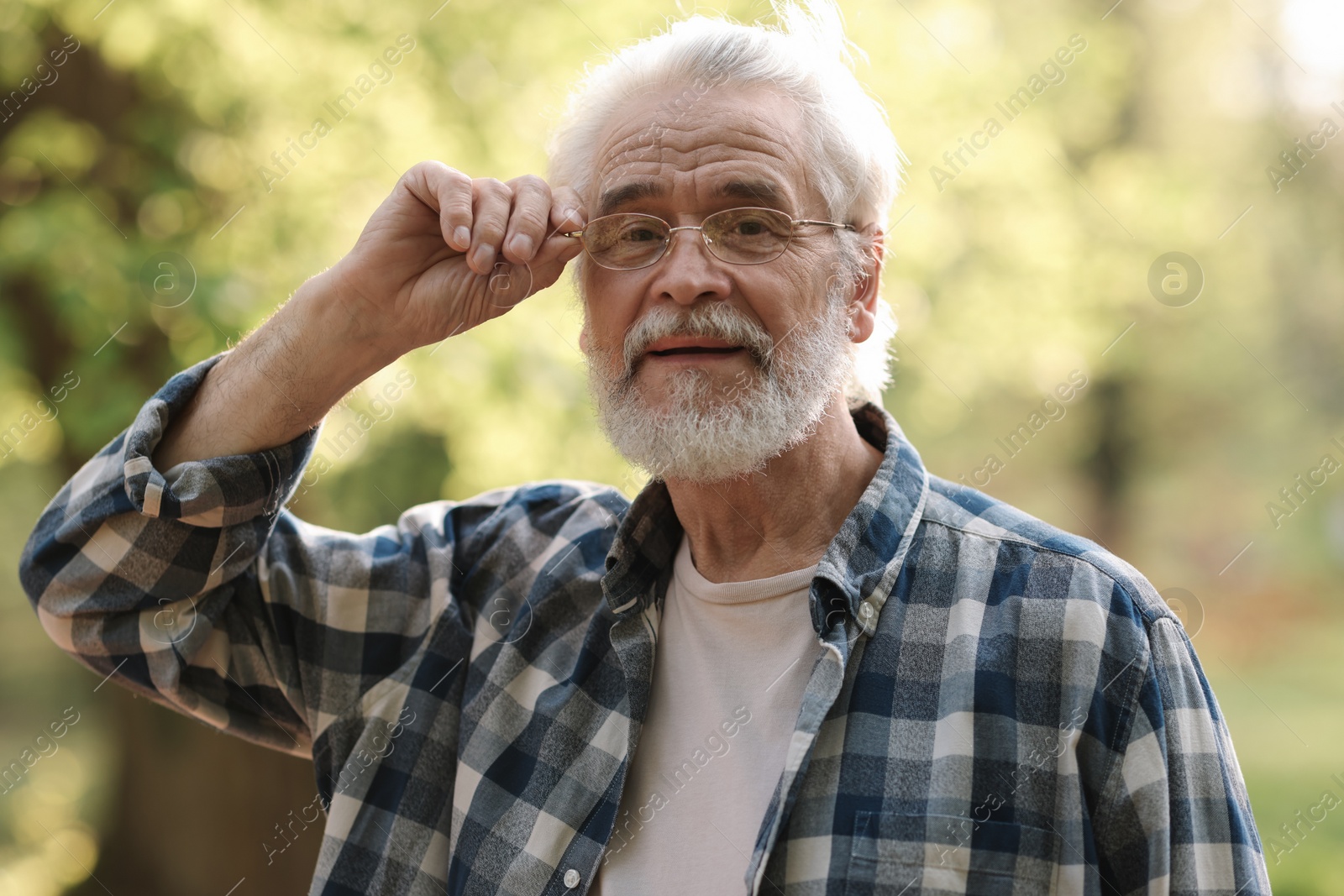 Photo of Portrait of happy grandpa with glasses in park