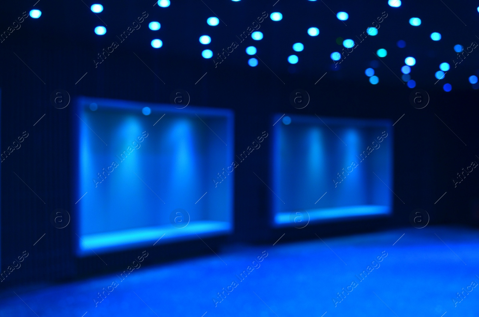 Photo of Blurred view of room with wall niches and ceiling lights, bokeh effect