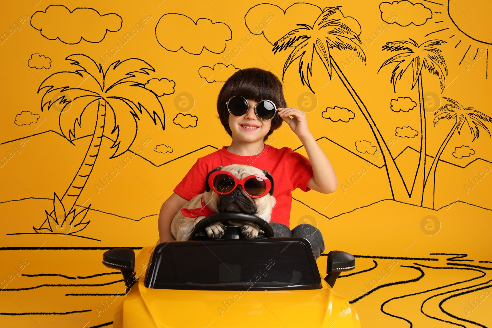 Image of Cute little boy with his dog in toy car and drawing of tropical resort on yellow background