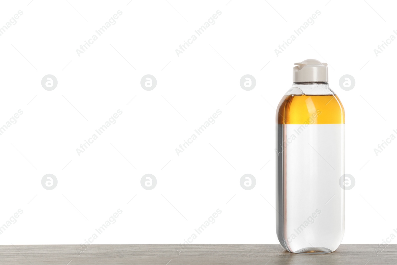 Photo of Micellar water on table against white background. Space for text