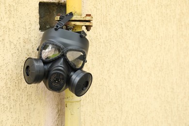 One gas mask hanging on building outdoors. Space for text