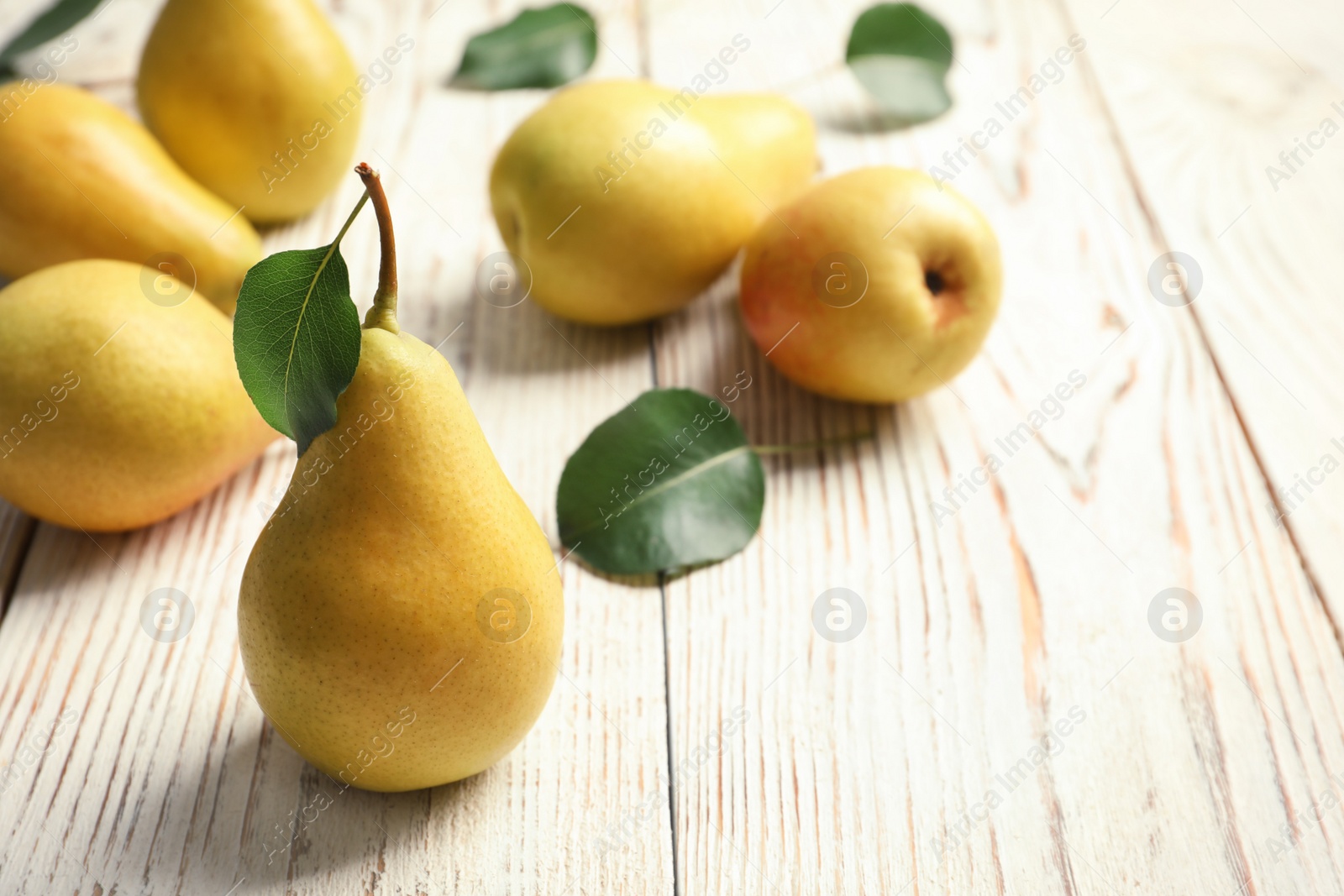 Photo of Ripe pears on wooden table. Space for text