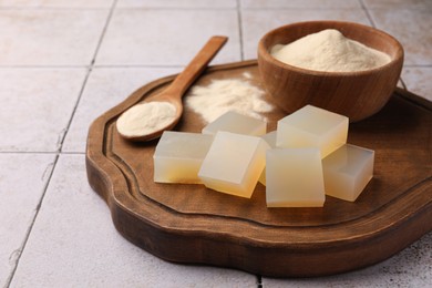 Photo of Agar-agar jelly cubes and powder on tiled surface