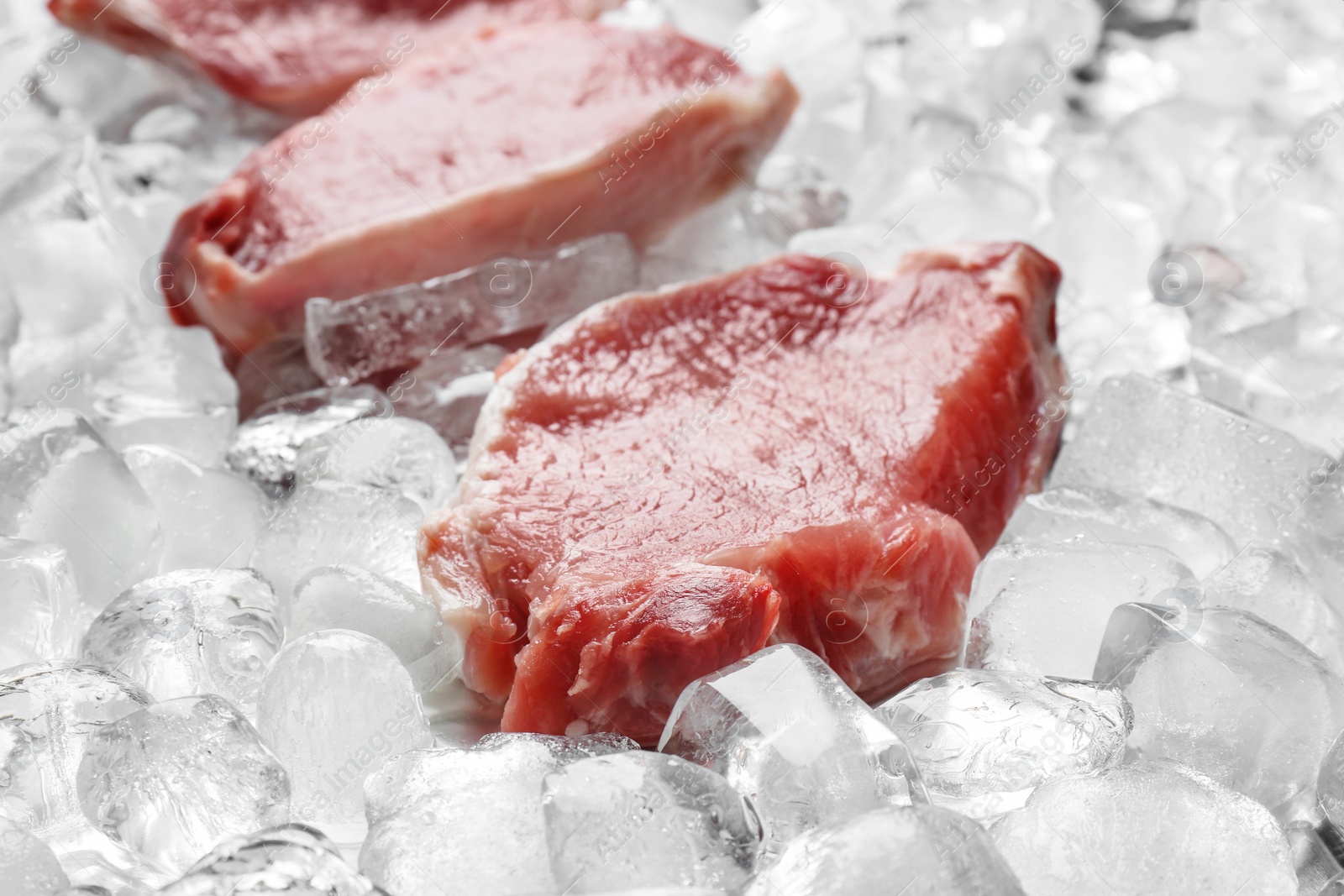 Photo of Fresh raw meat on ice cubes, closeup