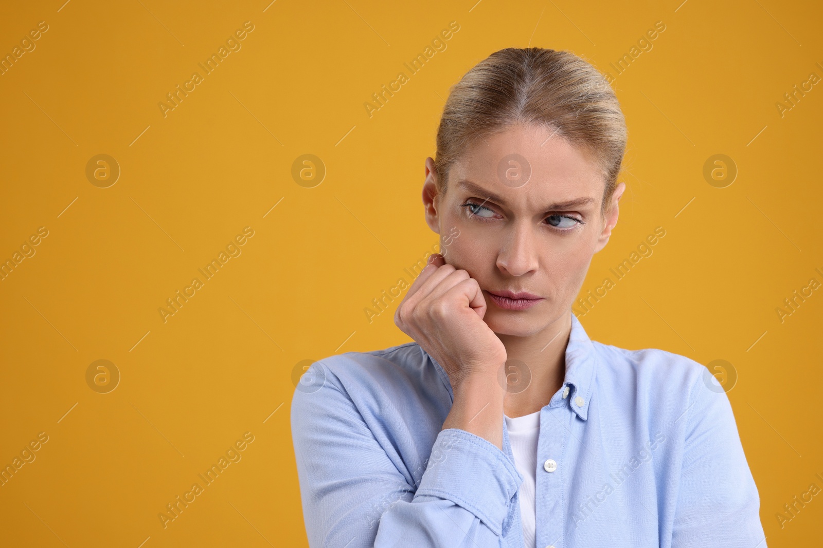 Photo of Resentful woman on orange background. Space for text