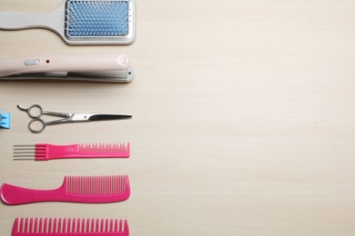 Photo of Flat lay composition of professional hairdresser tools on beige table, space for text