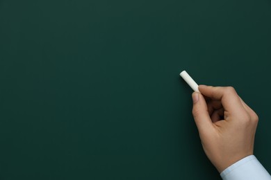 Photo of Man with white chalk near green board, closeup. Space for text