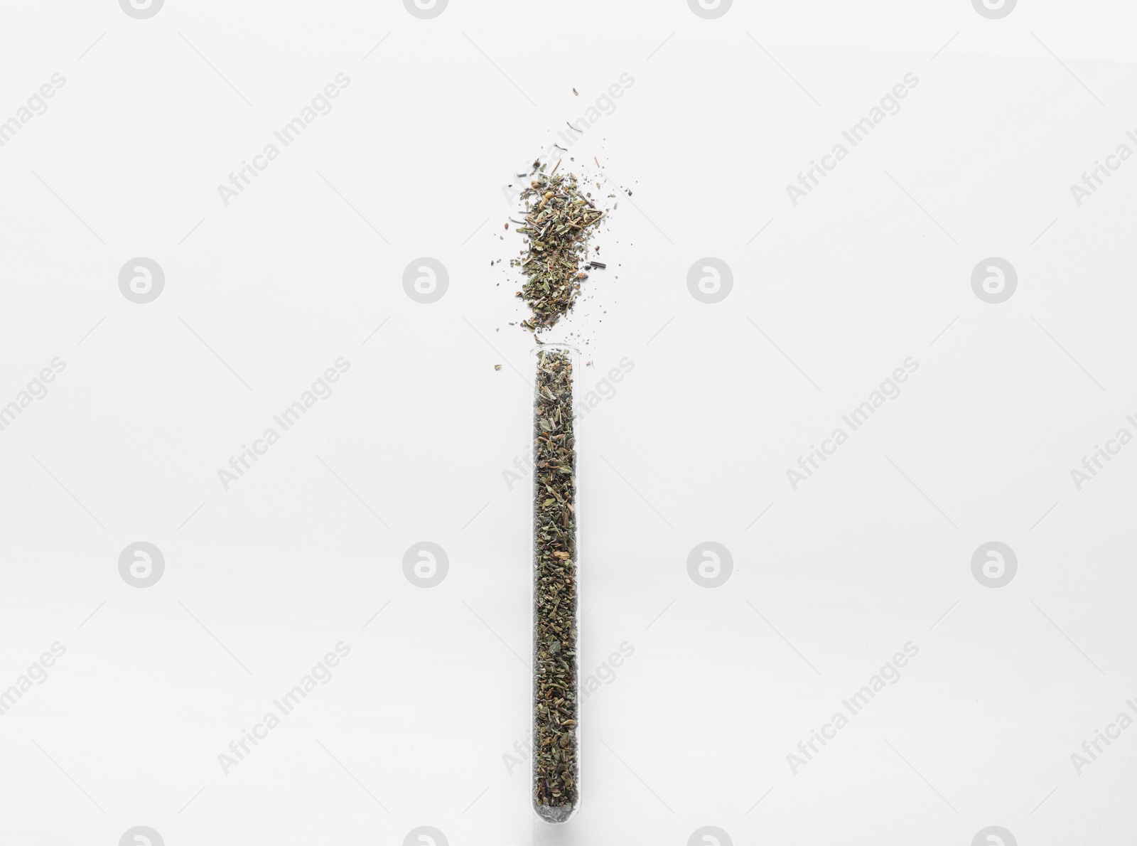 Photo of Glass tube with Italian herb mix on white background, top view