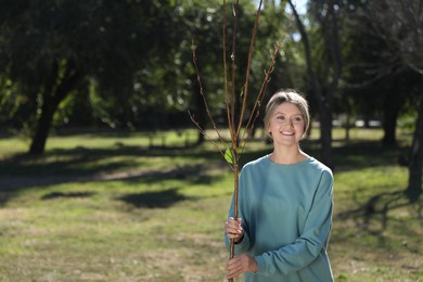 Photo of Happy woman with young tree ready for planting outdoors on sunny day