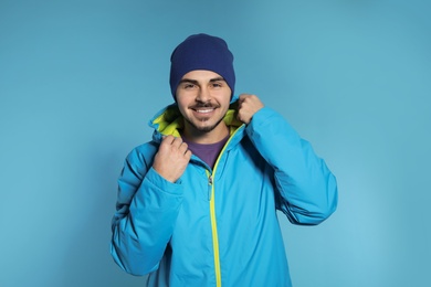 Photo of Young man wearing warm clothes on color background. Ready for winter vacation