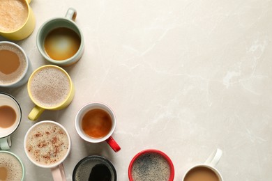Photo of Many cups with different aromatic coffee on light grey marble table, flat lay. Space for text